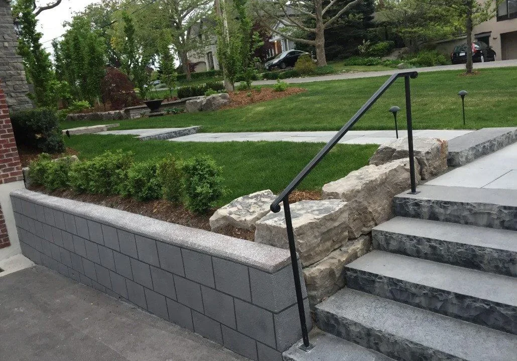 A rebuilt concrete retaining wall with steps and landscaping