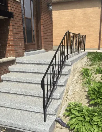 Rebuilt concrete steps with a new black railing after repair in Toronto
